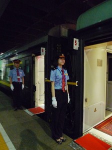 Train attendants standing attentively at the doors
